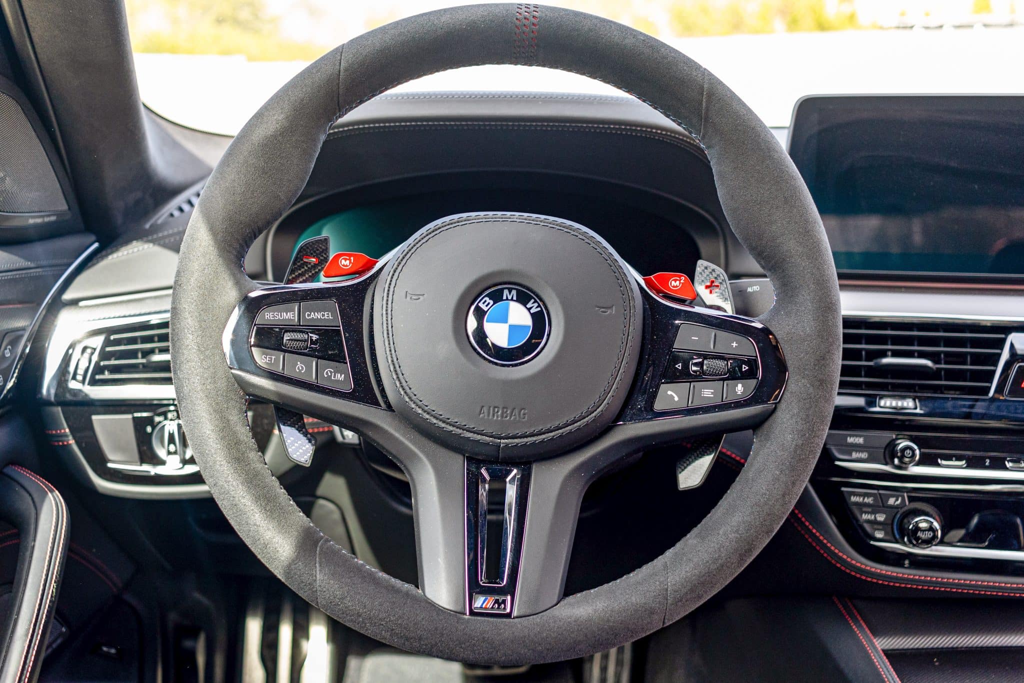 Alcantara steering wheel and M1/M2 drive-mode buttons in a BMW M5 CS