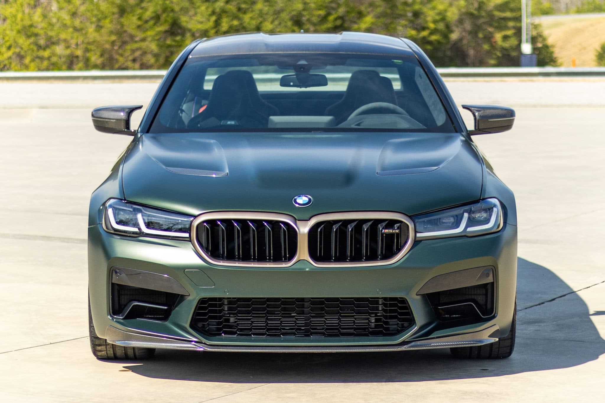 Matte green BMW M5 CS photographed head-on, from a Carviondealer listing