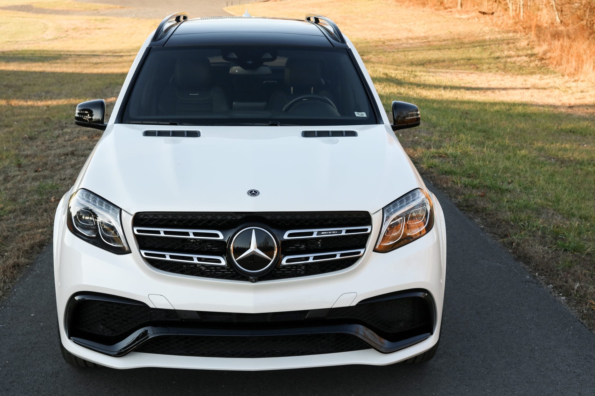 White Mercedes-AMG GLS 63 photographed on an open road at golden hour — the kind of vehicle delivered nationwide by enclosed or open transport